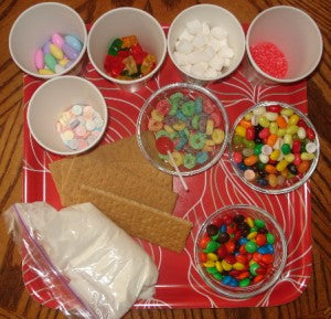 Feel free to use any type of candy you like. Pictured here you see the tray for the house, candy, graham crackers and bag of frosting.